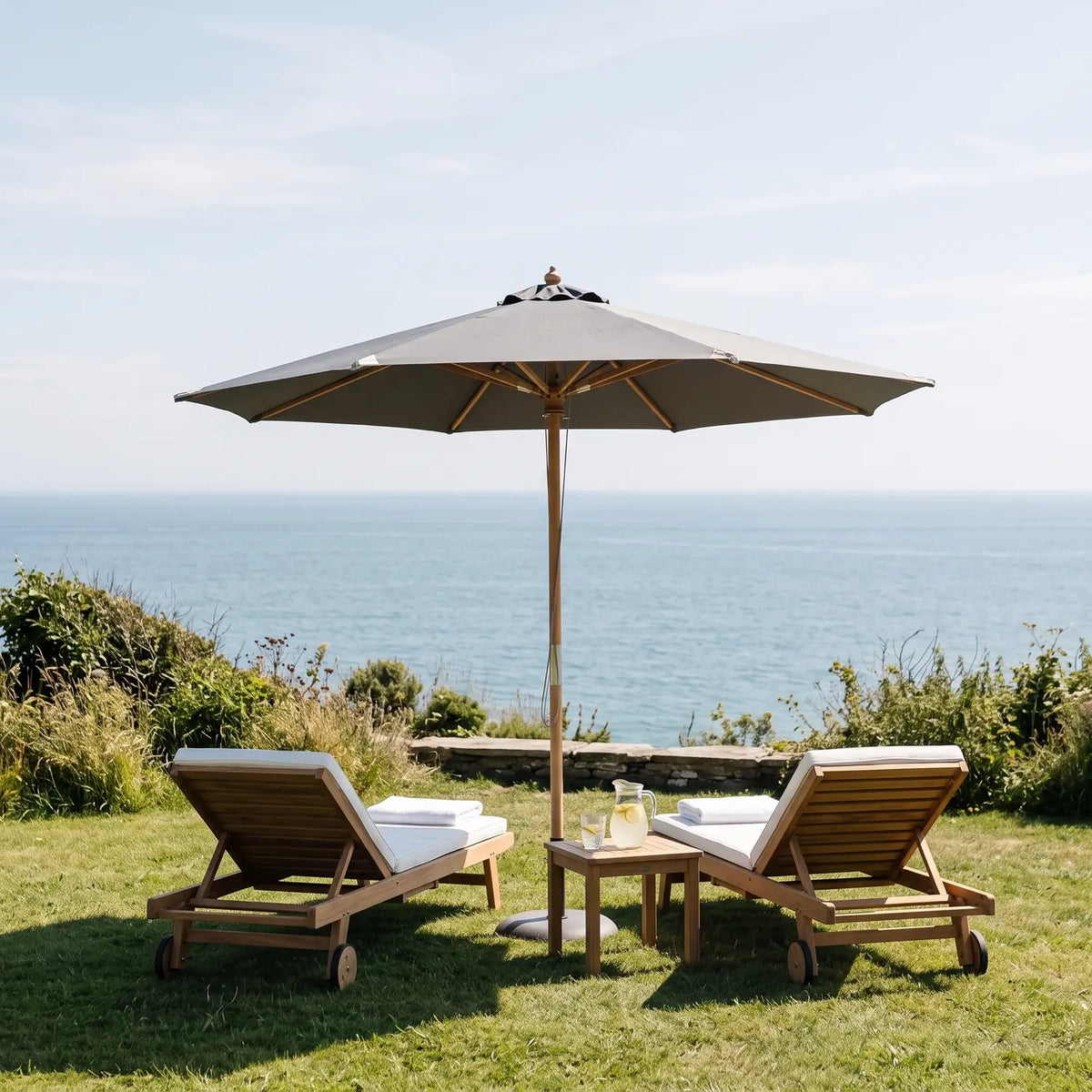Nice Parasol Ø3 m in grey over two sun loungers on a seaside lawn