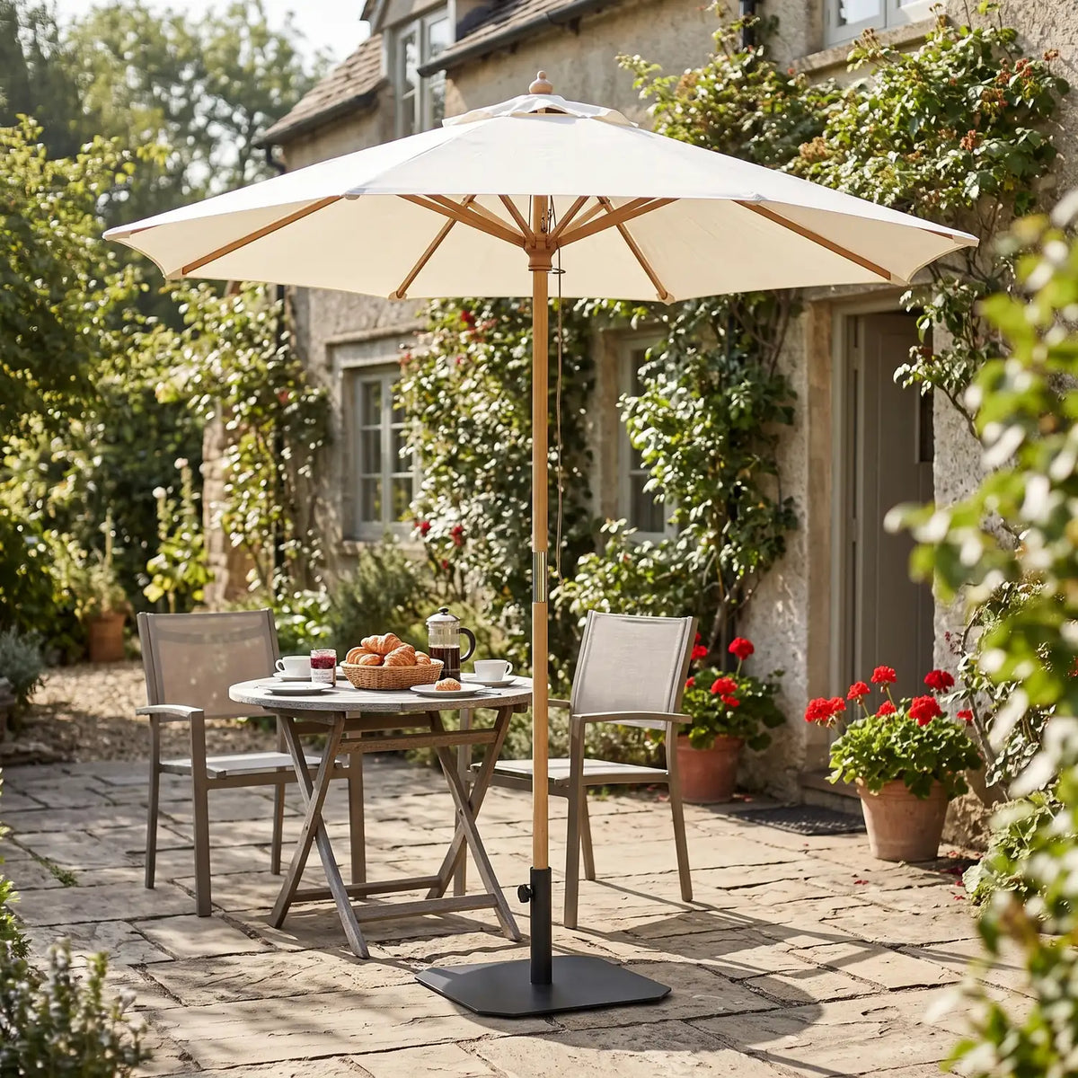 Venedig Parasol Ø1.8 m in natural standing in a black iron base over a breakfast table for two